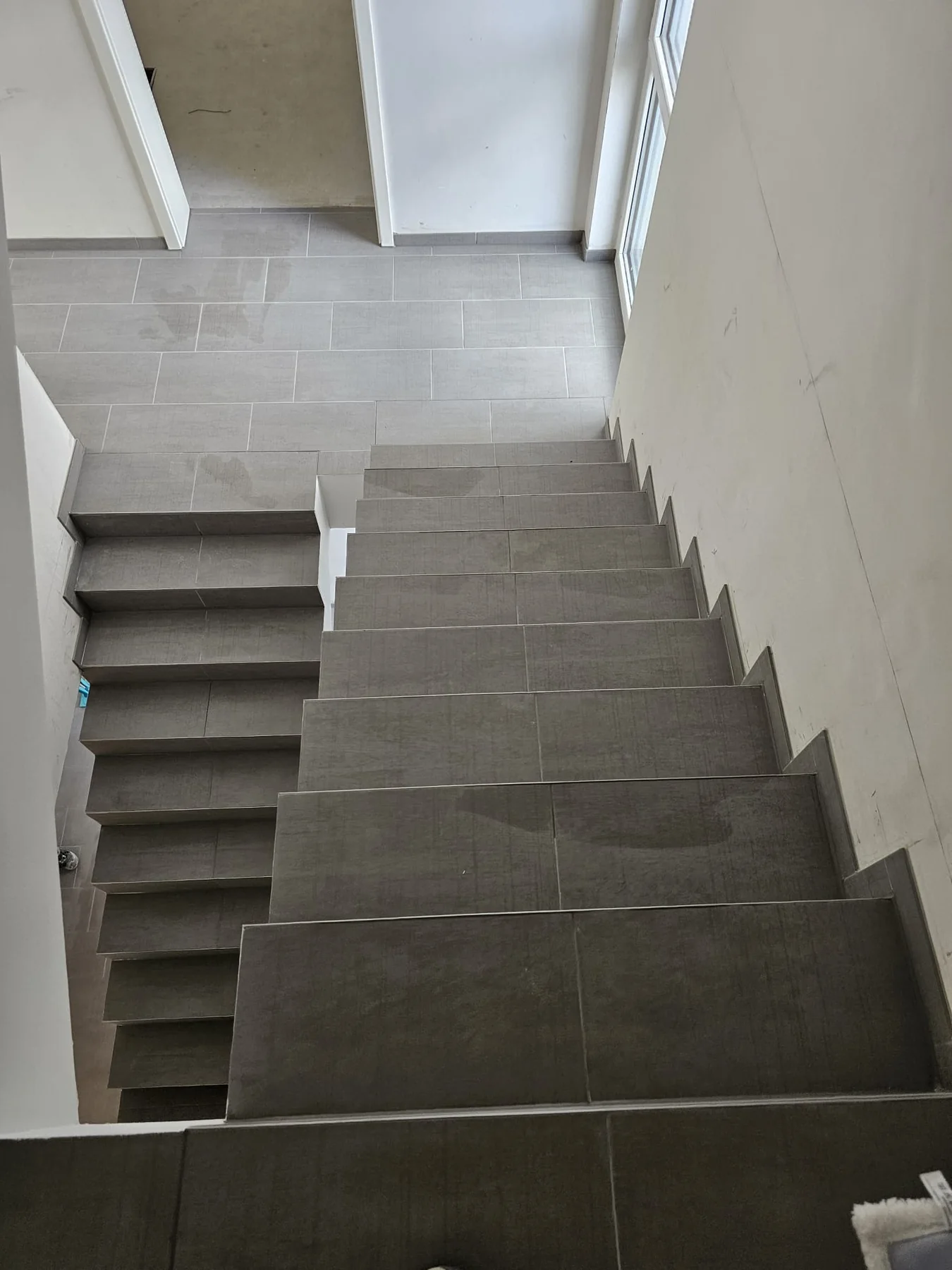 Geflieste Treppe und Bodenfläche mit grauen Fliesen