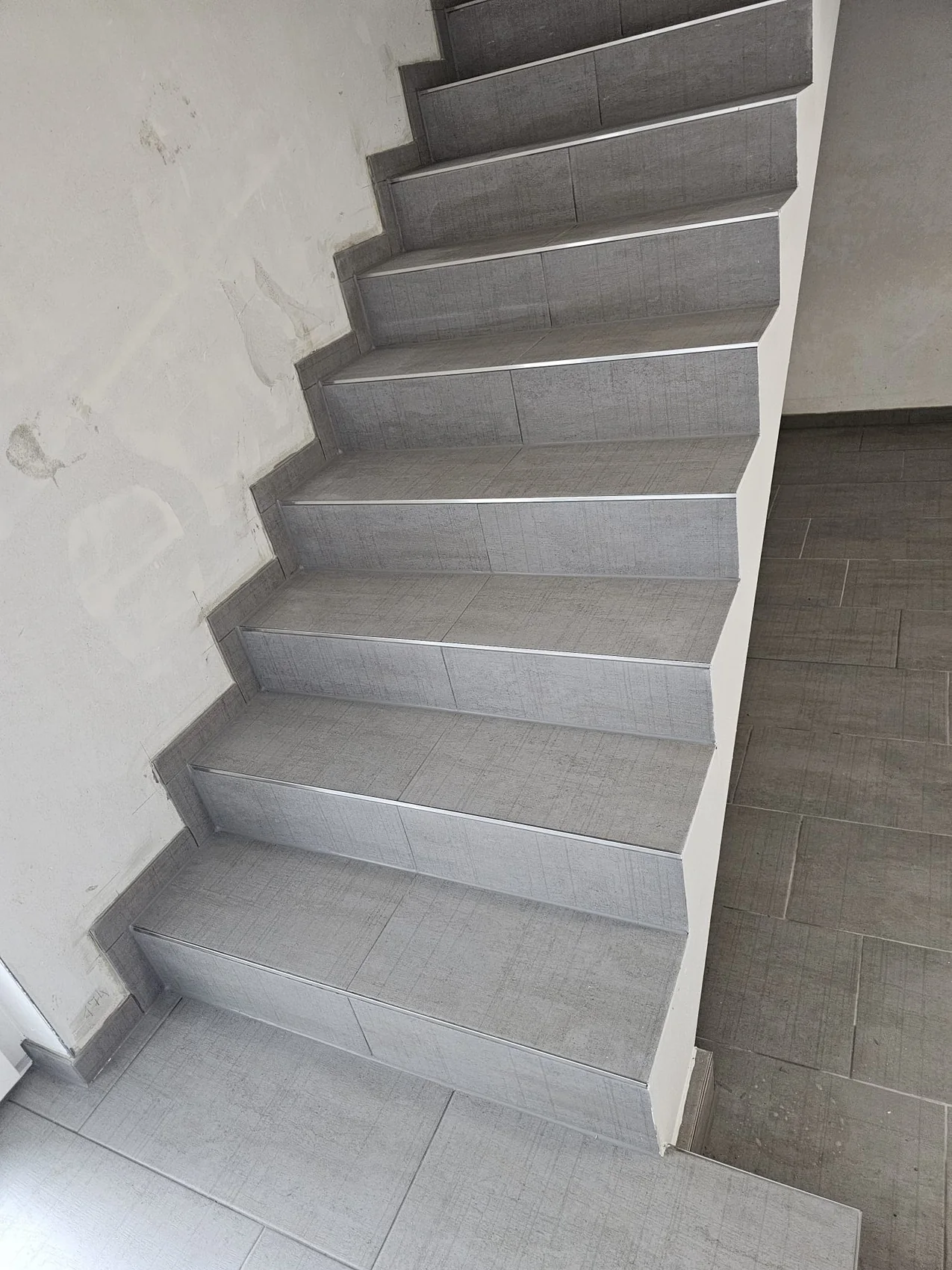 Geflieste Treppe mit grauen Stufen und sauberem Kantenabschluss